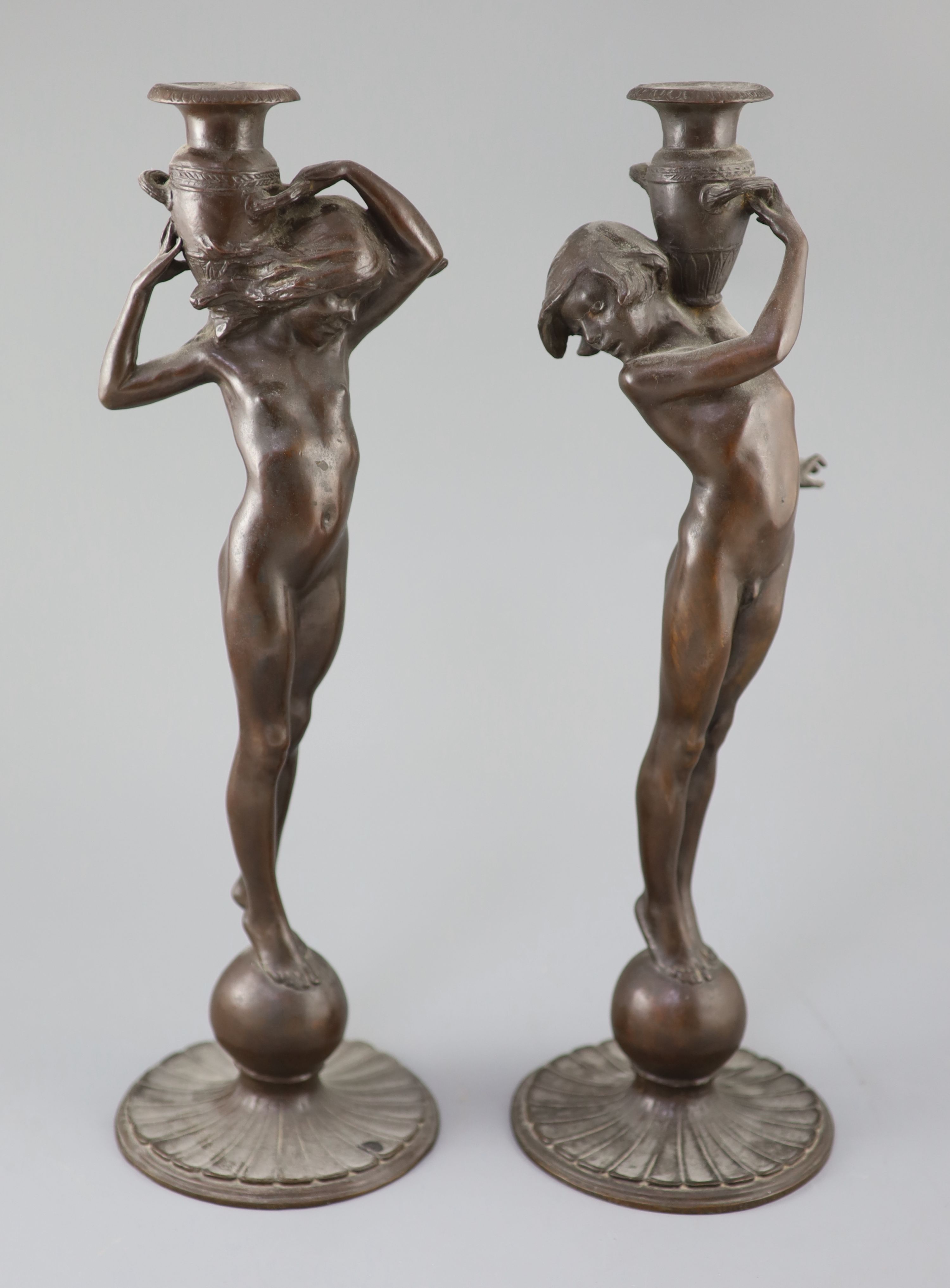 After Edward Francis McCartan (1879-1947). A pair of Art Nouveau bronze candlesticks, height 16.75in.